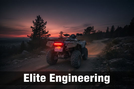 ATV at dusk on a dirt trail with a glowing LED light illuminating the rear license plate, Elite Engineering branding visible